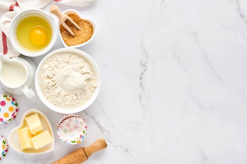 Preview: Baking background with flour, eggs, kitchen tools, utensils and cookie molds on white marble table.