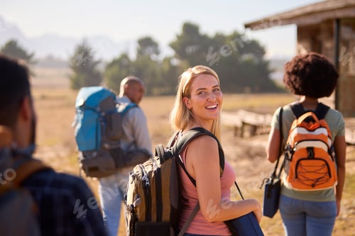 Preview: Group Of Friends With Backpacks Hiking In Countryside Together