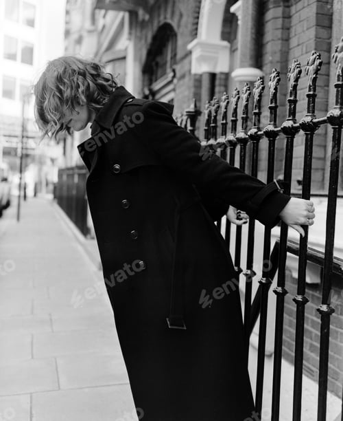 Preview: Unrecognizable woman holding bars and leaning in the street.