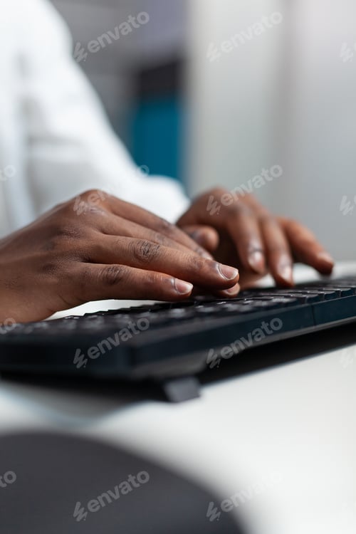 Preview: Closeup of african american specialist doctor typing medical expertise on computer