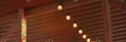 Preview: Banner warm string lights hanging in wooden interior with blurred background