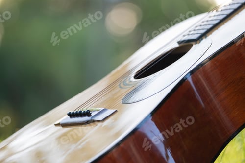Preview: Acoustic guitar outdoors on greenery background. Concept of calm music