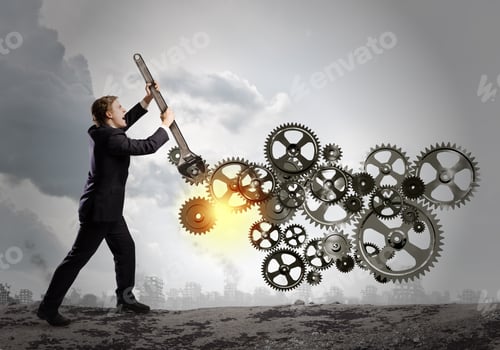 Preview: Young Businessman Fixing Gears Mechanism With Wrench