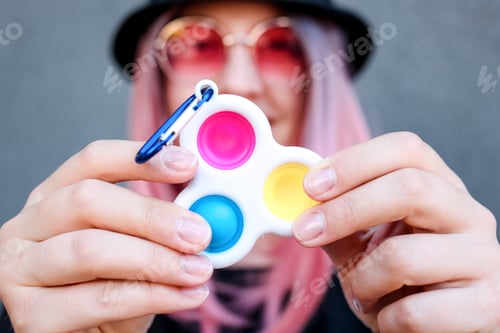 Preview: Young Girl Holding pink Pop It Fidget Toy in hands. Teen Playing