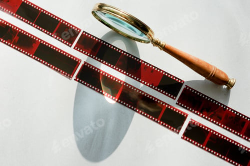 Preview: Analog photography filmstrip. Negatives and retro magnifying glass.