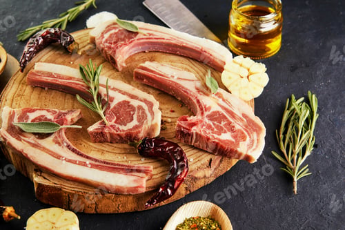 Preview: Raw lamb ribs with ingredients for cooking: salt, pepper, olive oil and herbs on a wooden stand