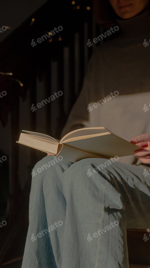 Preview: Woman reading sitting on stairs in sunlight
