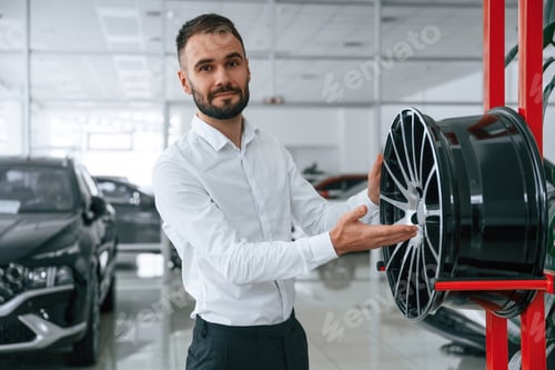 Preview: Worker in formal clothes is in the auto salon