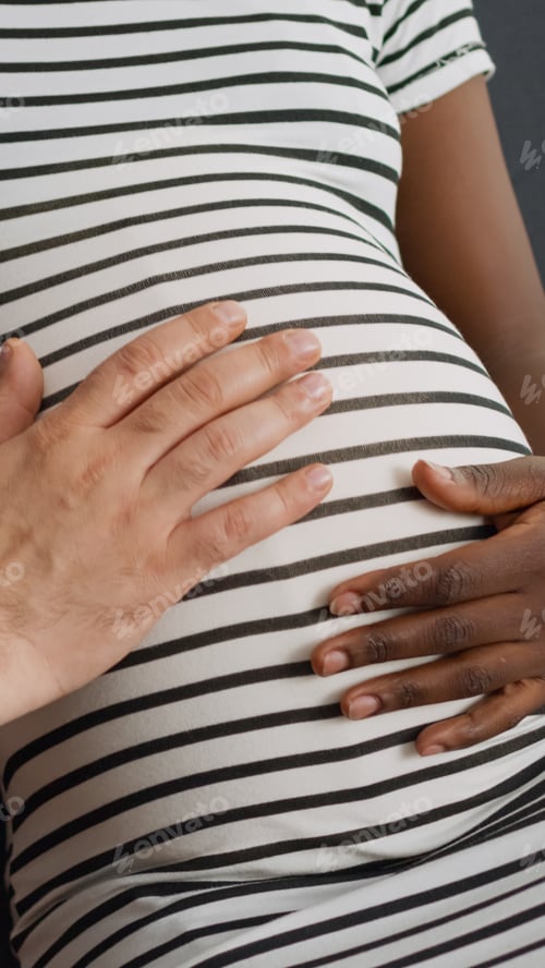 Preview: Close up of baby bump of pregnant black mother