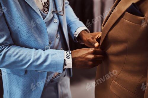 Preview: Elegantly dressed African-American man working at classic menswear store.