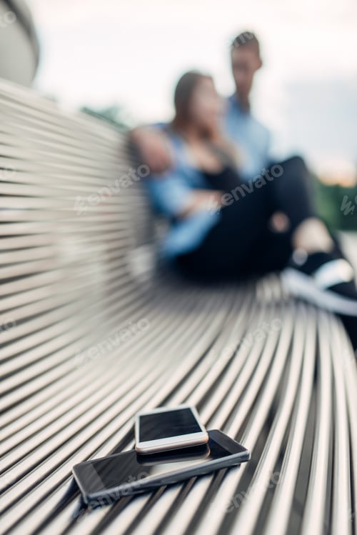 Preview: Phone addiction concept, two smartphones on bench
