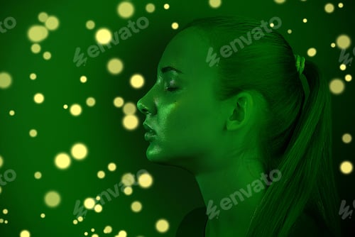 Preview: Young beautiful girl posing in a Studio with creative lighting. Artistic design, green tinting with