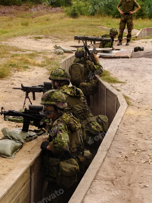 Preview: Trench warfare. Soldiers standing in a trench and aiming their rifles as an instructor looks on.