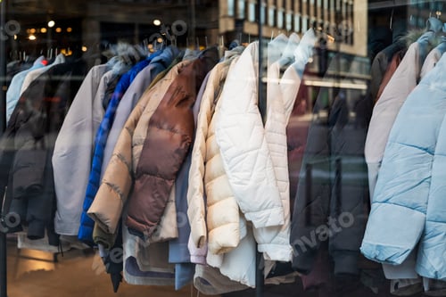 Preview: jackets clothes hanging on coat hangers in a store in a mall for sale on a showcase