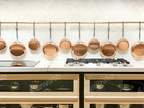 Preview: Copper pans hanging on display in a modern kitchen