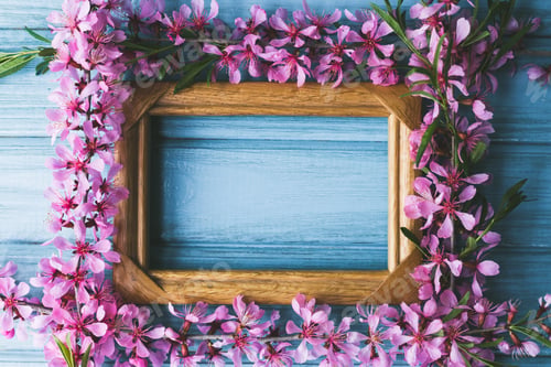 Preview: Spring flowers and frame on a blue wooden background