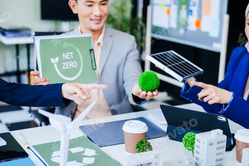 Preview: Trio of businesspeople, including a middle-aged Asian man and woman, strategize at their desk