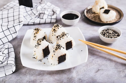 Preview: Homemade onigiri rice balls with tuna and nori on a plate on the table