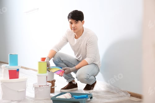 Preview: Male decorator holding color palette samples on white background