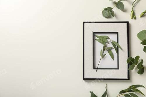 Preview: Fresh plants and photo frame on light background, space for text