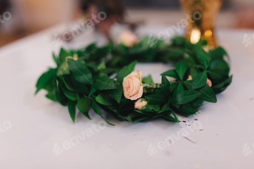 Preview: wreath with green leaves and pink roses on a white background. wedding crown. selective focus