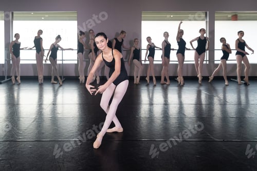 Preview: Teenage girl in ballet dance studio poses with the rest of the class behind her