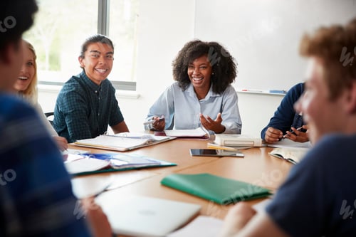 Preview: Female High School Tutor Sitting At Table With Pupils Teaching Maths Class