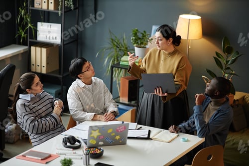 Preview: Woman presenting ideas to multiethnic team