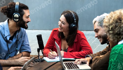 Preview: Millennial content creators record podcast outdoors with microphone and laptop.