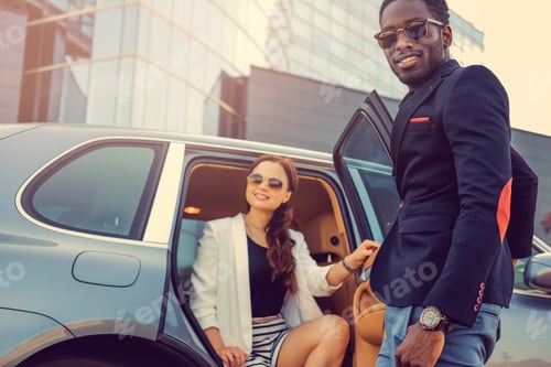 Preview: Casual couple posing near a car.
