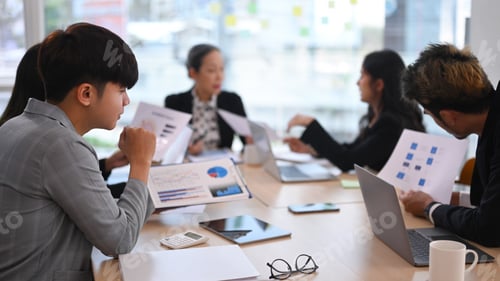 Preview: Concentrated diverse employees listening intently during discussion of development.