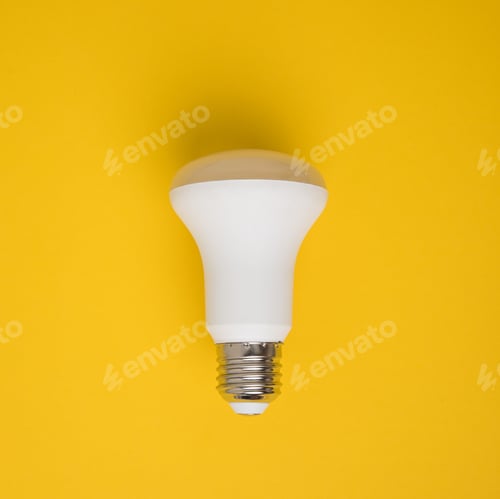 Preview: close up view of white light bulb isolated on yellow