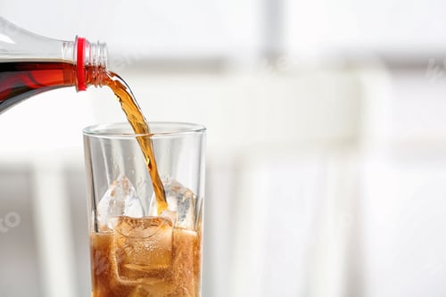 Preview: Pouring cola from bottle into glass on blurred background, closeup. Space for text