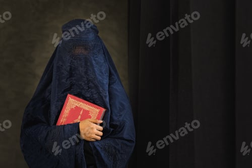 Preview: Asian women with burka reading the Islamic Quran