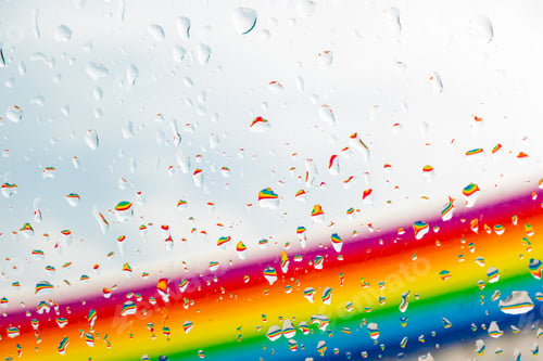 Preview: A rainbow behind a glass windows with water drops, Point of view, from behind the glass with drops.
