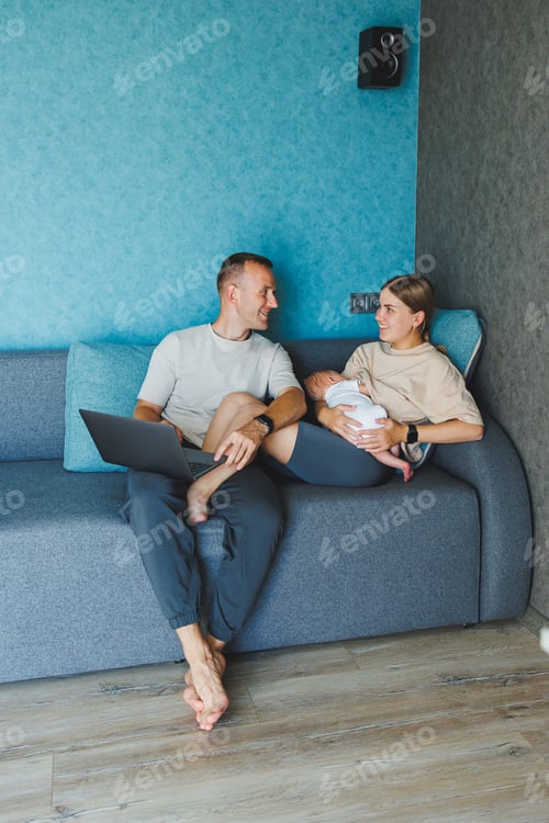 Preview: Happy family mom, dad and cute baby son having fun using laptop at home. Young parents and funny
