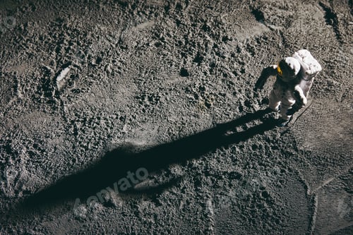 Preview: High angle shot of an astronaut miniature toy on the moon