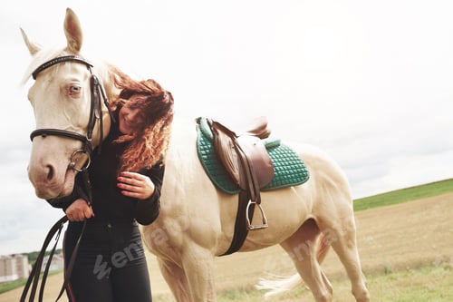 Preview: A happy girl communicates with her favorite horse. The girl loves animals andhorseback riding