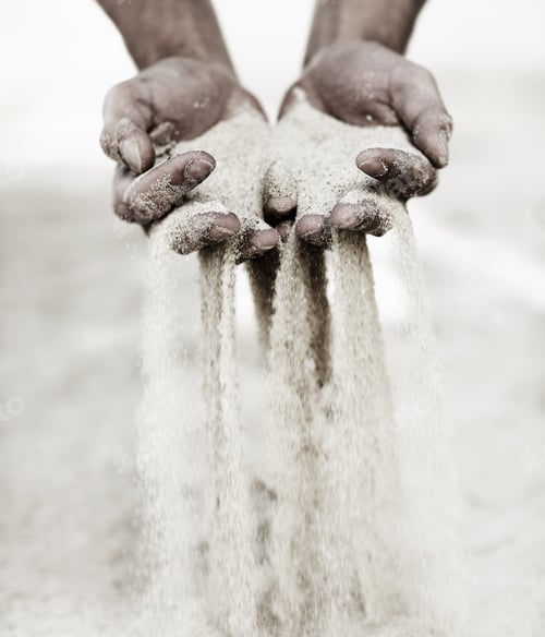 Preview: Touching the beach. Shot of a man with a handful of sand falling through his fingers.