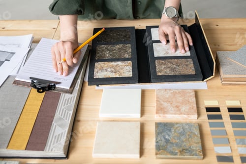 Preview: Hands of young woman making notes on paper while choosing sample of panel
