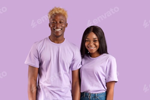Preview: Positive African American couple smiling and looking at camera on violet studio background