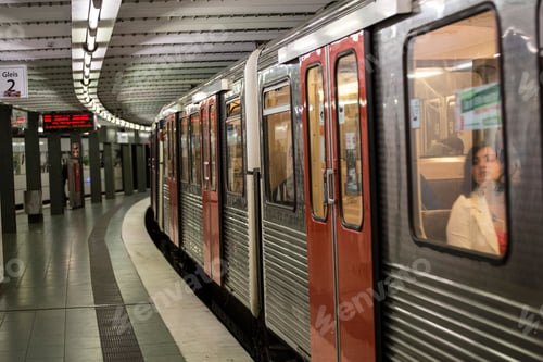 Preview: Woman gazing out from a subway train at the station