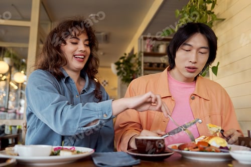 Preview: Multicultural friends enjoying brunch together at a cozy cafe during a sunny afternoon