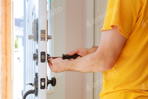 Preview: Worker installing or repairing new lock handyman repair the door lock