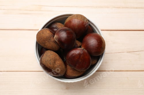 Preview: Sweet fresh edible chestnuts on light wooden table, top view