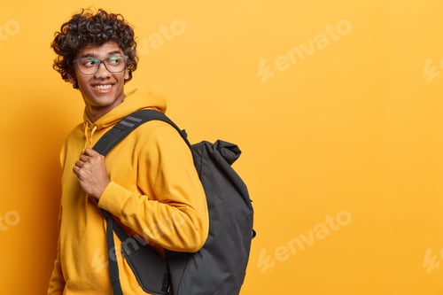 Preview: Student lifestyle. Studio sideways shot of young cheerful smiling Hindu male wearing yellow hoodie