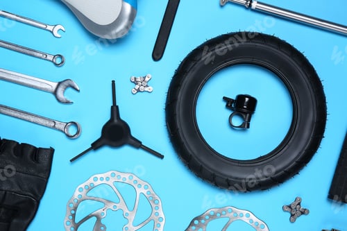 Preview: Set of different bicycle tools and parts on light blue background, flat lay