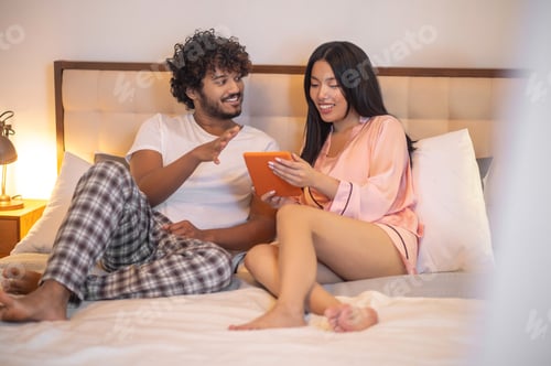 Preview: Couple Relaxing Together in Bed with Tablet
