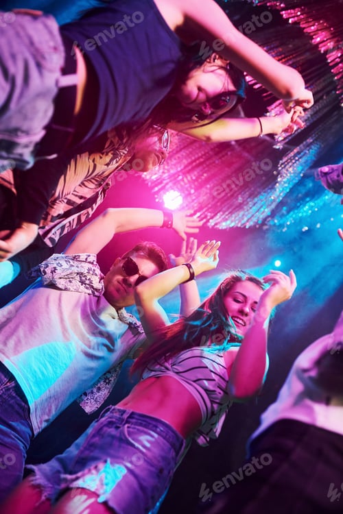 Preview: View from below of young people that having fun in night club with colorful laser lights