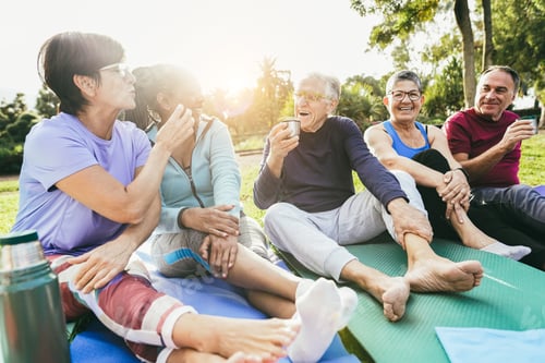 Preview: Senior people having fun drinking hot tea after yoga lesson at city park - Multiracial mature friend